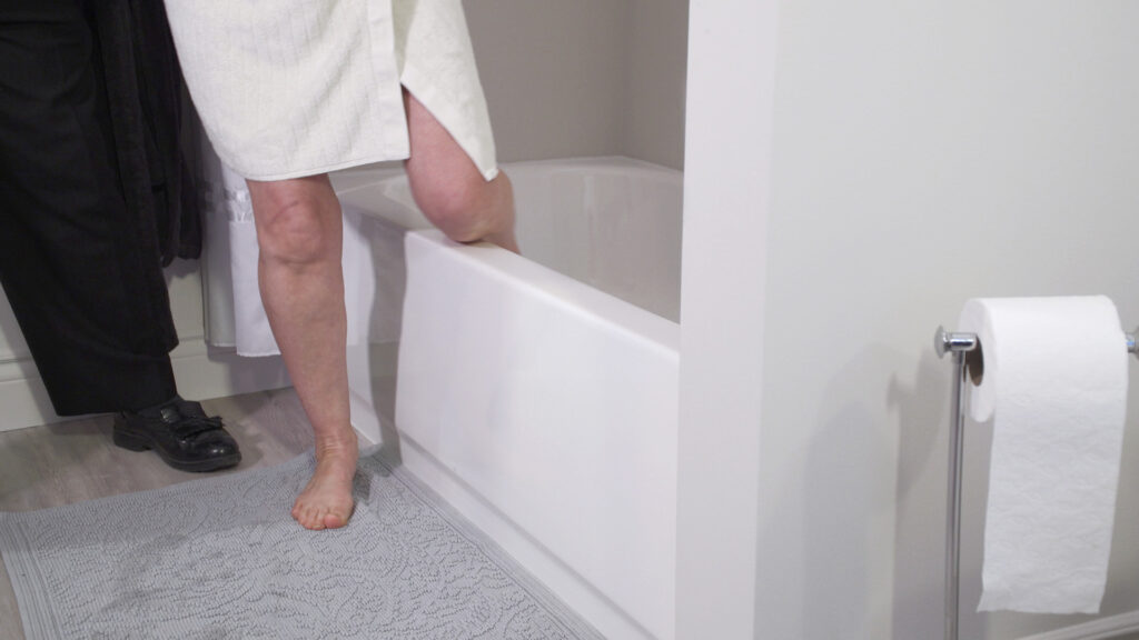 Older adult using an easier-entry bathtub conversion